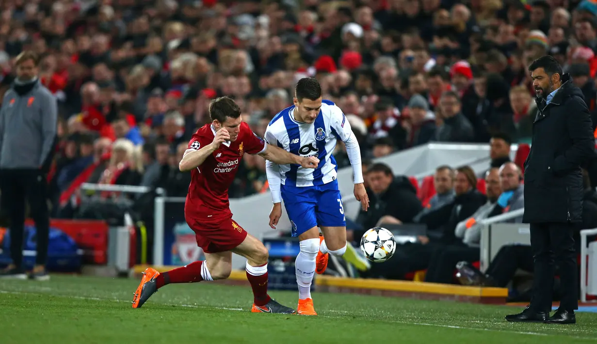 Pemain Liverpool, James Milner berebut bola dengan pemain FC Porto Diogo Dalot pada leg kedua babak 16 besar Liga Champions di Stadion Anfield, Selasa (6/3). Liverpool lolos ke perempatfinal berbekal kemenangan 5-0 secara agregat. (AP/Dave Thompson)