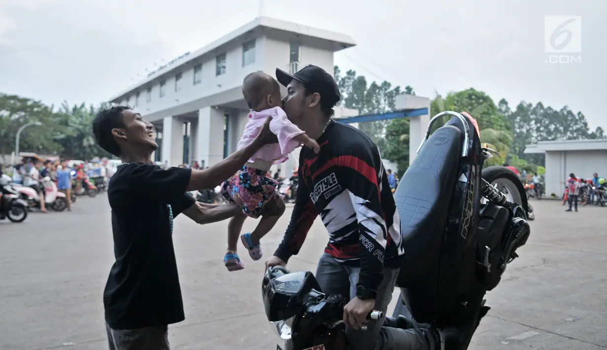 Freestyler motor mencium bayi saat meramaikan waktu menjelang berbuka puasa atau ngabuburit di Banjir Kanal Timur (BKT), Jakarta, Minggu (12/5/2019). Aksi para freestyler menari di atas kuda besi menjadi daya tarik sekaligus tontonan warga yang sedang ngabuburit di BKT. (merdeka.com/Iqbal Nugroho)