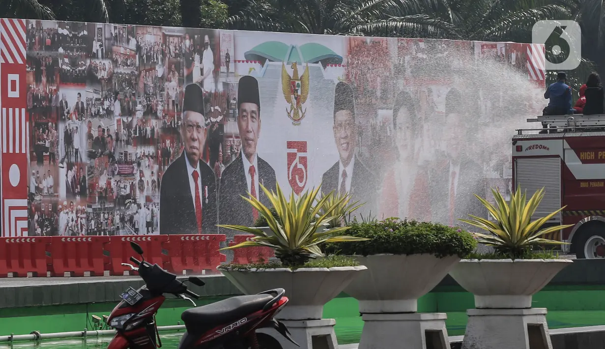 Petugas menyemprotkan cairan disinfektan di Kompleks Parlemen, Jakarta, Minggu (9/8/2020). Rapat Paripurna terbuka DPR RI tahun 2020 dengan acara Pidato Kenegaraan Presiden RI dan Pengantar keterangan Pemerintah atas RAPBN tahun 2021 berlangsung Jumat (14/8/2020). (Liputan6.com/Johan Tallo)