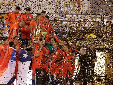 Para pemain Chile bergembira mengangkat trofi kemenangan usai mengalahkan Argentina pada Final Copa America 2016 di MetLife Stadium, AS, Senin (27/6). Chile menang atas Argentina lewat adu penalti dengan skor 4-2. (Adam Hunger-USA TODAY Sports)