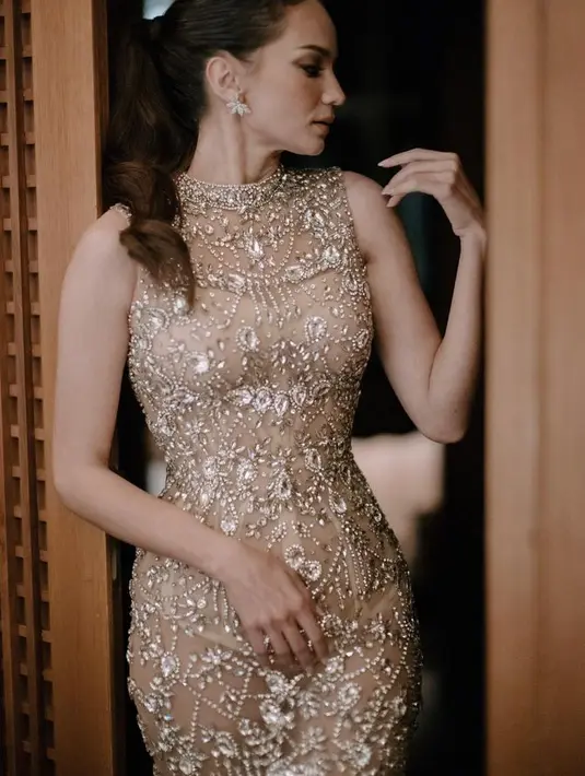 Gaun model nude tersebut memperlihatkan keseksian sekaligus glamor secara bersamaan. Belum lagi detail bebatuan yang membuatnya paling berkilau dan memukau. [Foto: Instagram @monicaivena]