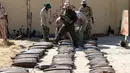 Pasukan pemerintah Libya yang didukung PBB memindahkan sisa-sisa bahan peledak di sebuah kamp militer di Tripoli selatan, Libya (22/7/2020). (Xinhua/Hamza Turkia)