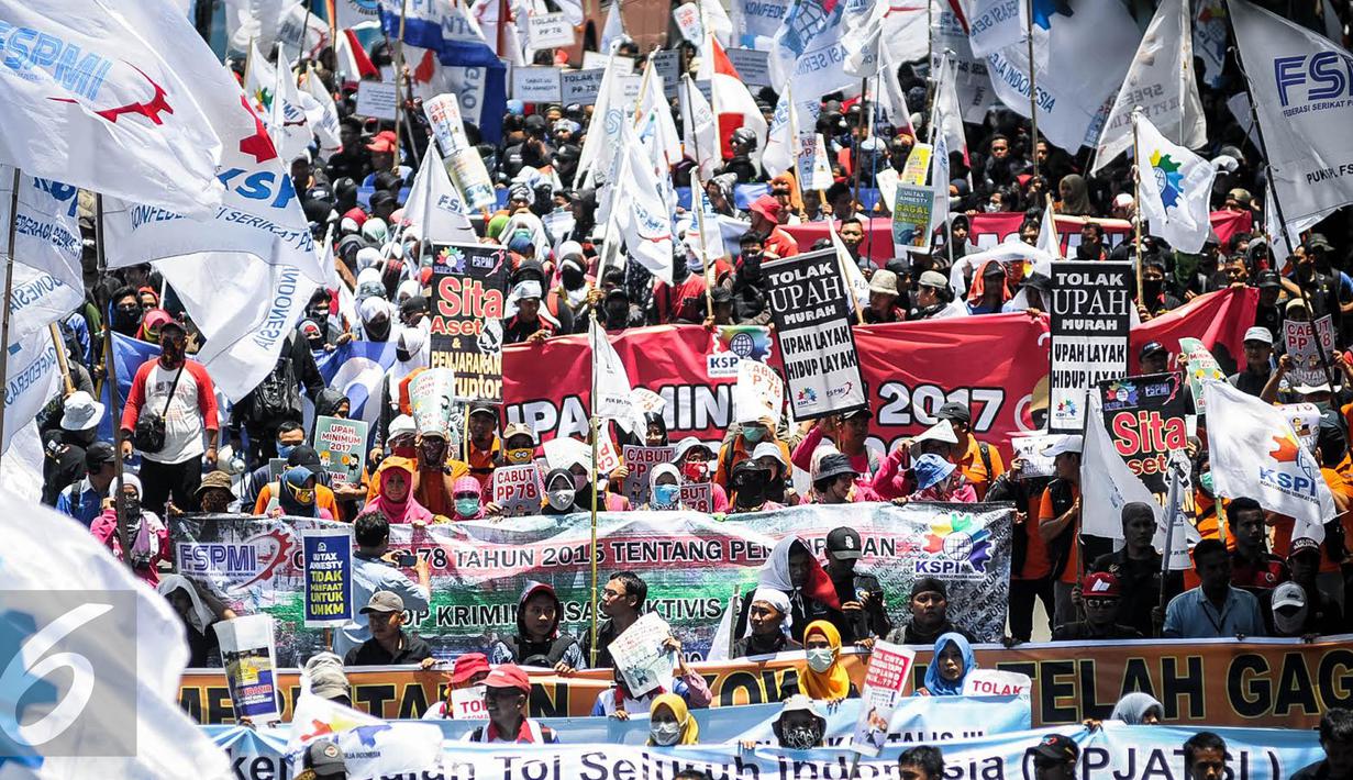 Ribuan buruh dari berbagai elemen melakukan longmarch menuju depan Istana Negara, Jakarta, Kamis (29/9). Dalam aksinya mereka menolak Tax Amnesty serta menaikan upah minumum provinsi (UMP) sebesar Rp650 ribu per bulan. (Liputan6.com/Faizal Fanani)