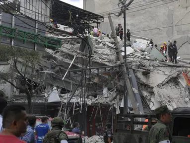 Tim penyelamat bekerja mencari korban di antara reruntuhan sebuah bangunan yang ambruk akibat gempa dahsyat di Mexico City, meksiko, Selasa (19/9). Gempa dahsyat berkekuatan 7,1 Skala Richter mengguncang Ibu Kota Mexico City. (Omar Torres/AFP)