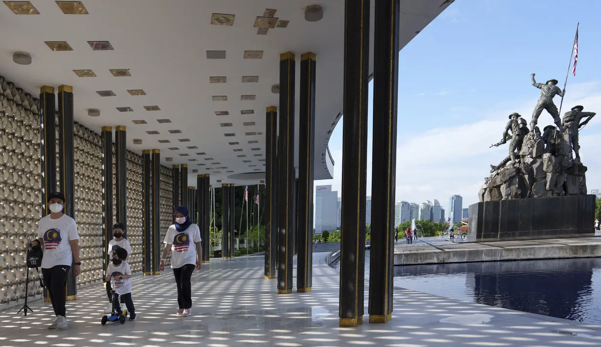 Sebuah keluarga mengunjungi Monumen Nasional saat perayaan Hari Nasional ke-64 untuk memperingati kemerdekaan Malaysia dari penjajahan Inggris di Kuala Lumpur, Malaysia, Selasa (31/8/2021). (AP Photo/Vincent Thian)