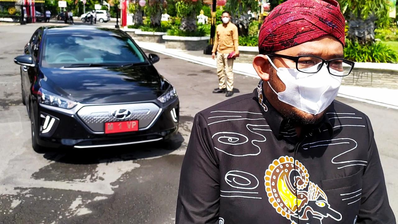 Bupati Sumenep Ahmad Fauzi dengan mobil listrik yang menjadi kendaraan dinas. (Dian Kurniawan/Liputan6.com).