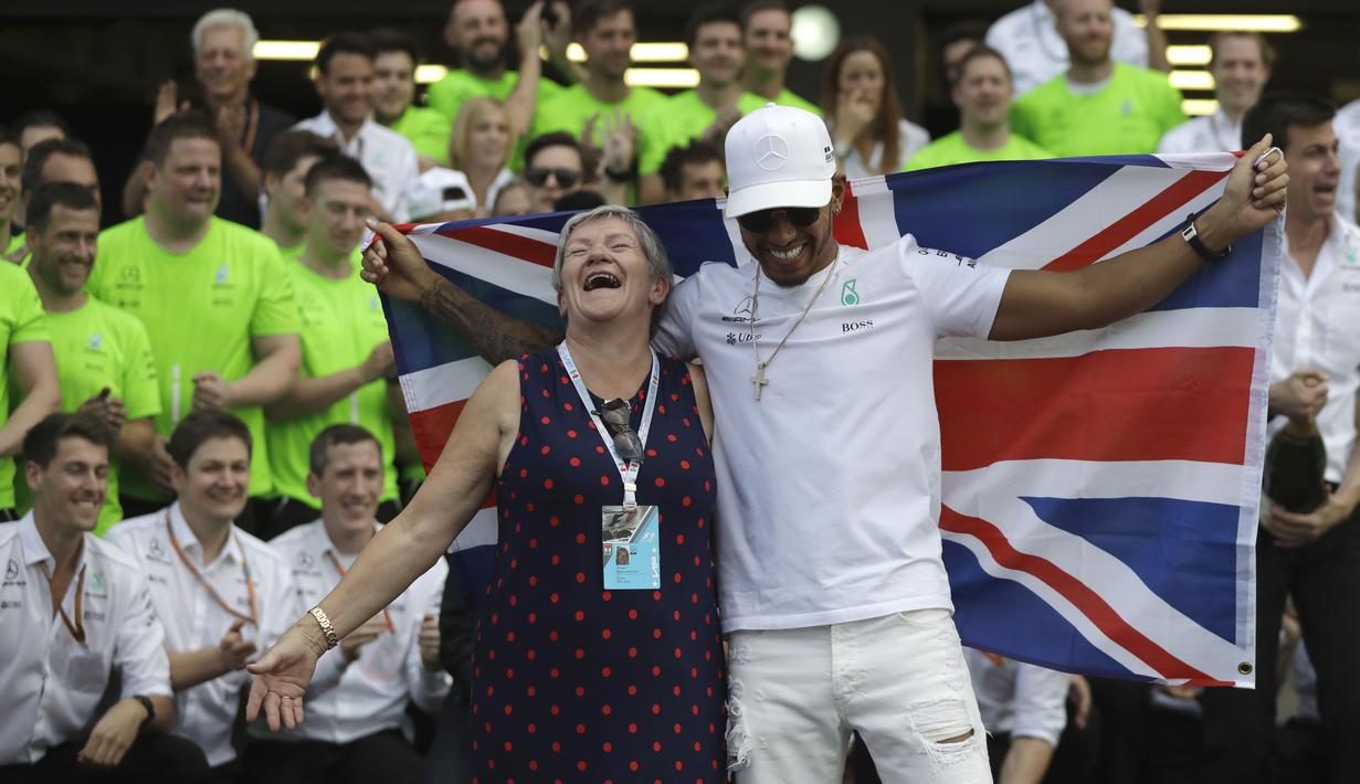 Lewis Hamilton merayakan keberhasilan merebut gelar juara Dunia F1 2017 bersama ibunya, Carmen Larbalestier di Hermanos Rodriguez racetrack, Mexico City, (29/10/20170). Hamilton finis kedelapan pada balapan tersebut.(AP/Rebecca Blackwell)