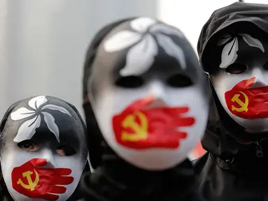 Demonstran mengenakan topeng saat berkumpul untuk menunjukkan dukungan kepada Uighur dan perjuangan mereka terhadap hak azasi manusia (HAM) di Hong Kong, Minggu (22/12/2019). Demonstran memprotes kebijakan China terkait minoritas Uighur. (AP Photo/Lee Jin-man)