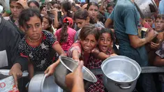 Anak-anak perempuan Palestina berkumpul untuk menerima makanan matang dari pusat distribusi makanan di kamp pengungsi Nuseirat di Jalur Gaza tengah pada 18 Agustus 2025. (Eyad BABA/AFP)