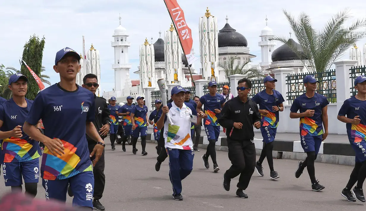 Wakil Manajer Aceh United Football Club, M Nasir Gurumud saat kirab Obor (torch relay) Asian Games di Banda Aceh, Selasa (31/7). Kirab Obor dimulai dari Museum Aceh dan berakhir di Kantor Gubernur Aceh. (Liputan6.com/Immanuel Antonius)