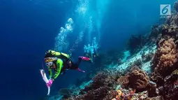 Ketua Umum WASI, Tri Suswati Karnavian membawa api obor Asian Games 2018 di perairan Pulau Piaynemo, Raja Ampat, Papua Barat, Kamis (26/7). Kegiatan ini sebagai bentuk dukungan perempuan terhadap kesuksesan Asian Games 2018. (Liputan6.com/HO/Mabes Polri)