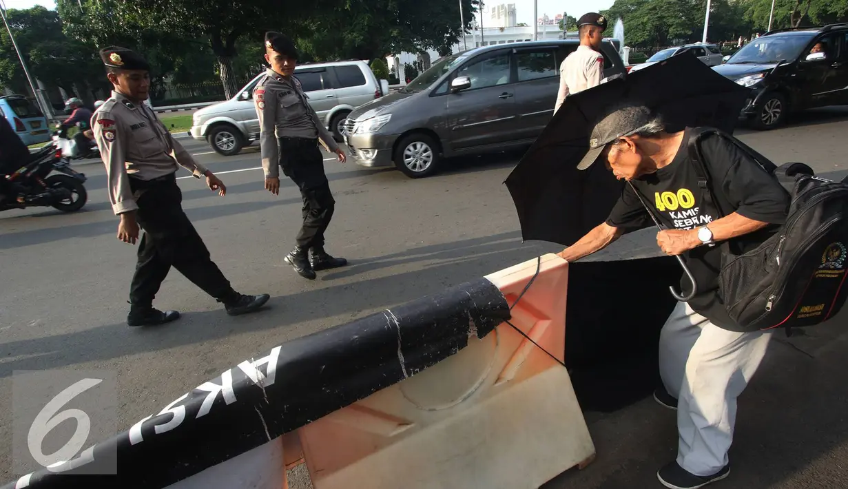Petugas berjaga saat aksi Kamisan ke-460 di depan Istana Merdeka, Jakarta, Kamis (22/9). Aksi ini memeringati 17 tahun Tragedi Semanggi II yang jatuh pada Sabtu, 24 September 2016. (Liputan6.com/Immanuel Antonius)