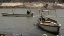 Seorang pria mengemudikan kapal feri kayu di sepanjang sungai Tigris saat permukaan air sungai semakin dangkal, di pusat ibu kota Irak, Baghdad, pada 26 Mei 2022. Bank Dunia memperkirakan bahwa tanpa perubahan besar, Irak akan kehilangan 20 persen sumber daya airnya pada tahun 2050, dan Irak diklasifikasikan sebagai salah satu dari lima yang paling rentan terhadap efek perubahan iklim dan penggurunan. (AHMAD AL-RUBAYE/AFP)