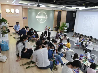 Orang-orang menghadiri kelas merangkai bunga di "Youth Channel" di Shenzhen, China (2/9/2020). Youth Channel adalah pusat komunitas yang menyediakan kuliah dan kelas budaya, seperti kursus ukulele dan keterampilan merangkai bunga bagi kaum muda sepulang bekerja. (Xinhua/Mao Siqian)