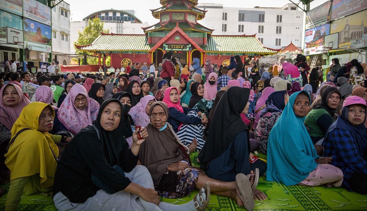 Bantuan ini untuk meringankan beban ekonomi warga saat bulan Ramadan dan menjelang Hari Raya Idul Fitri. Tampak dalam foto, warga mengantre untuk menerima bantuan uang tunai di masjid Cheng Hoo, Surabaya, Jawa Timur pada Rabu 4 Maret 2026. (JUNI KRISWANTO/AFP)