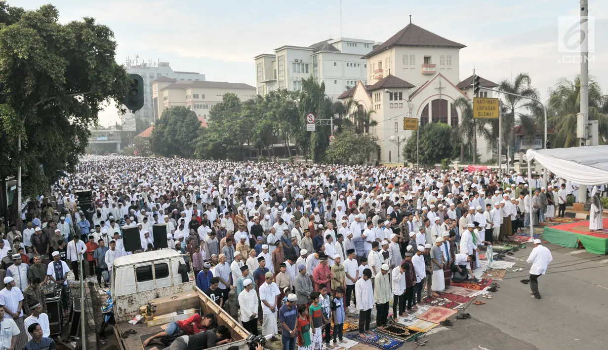 Dua pria tidur di atas mobil bak saat umat muslim melaksanakan salat Idul Fitri 1438 H di kawasan Jatinegara, Jakarta, Minggu (25/7). Ruas Jalan Jatinegara Barat disulap menjadi tempat pelaksanaan salat Ied. (Liputan6.com/Yoppy Renato)
