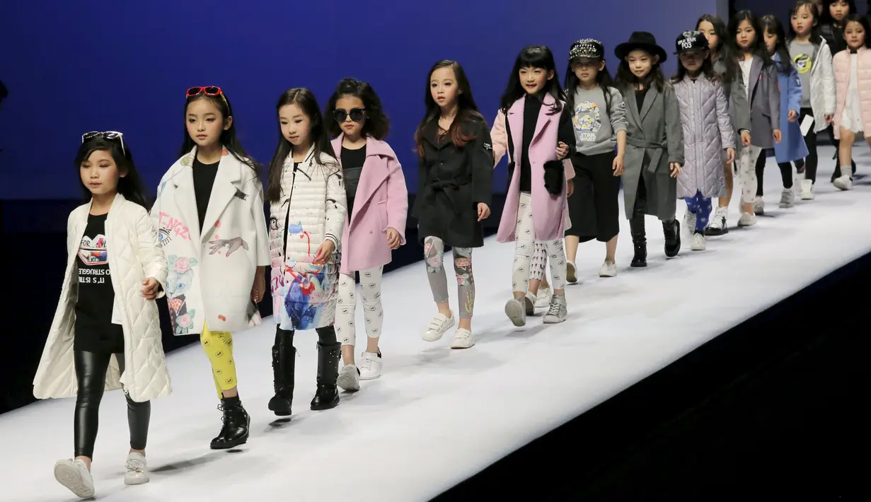 Sejumlah anak dengan lucunya berjalan diatas catwalk mengenakan busana kreasi dari Ting Zu pada China Fashion Week,  Cina , (27/3). (REUTERS / Kim Kyung - Hoon)