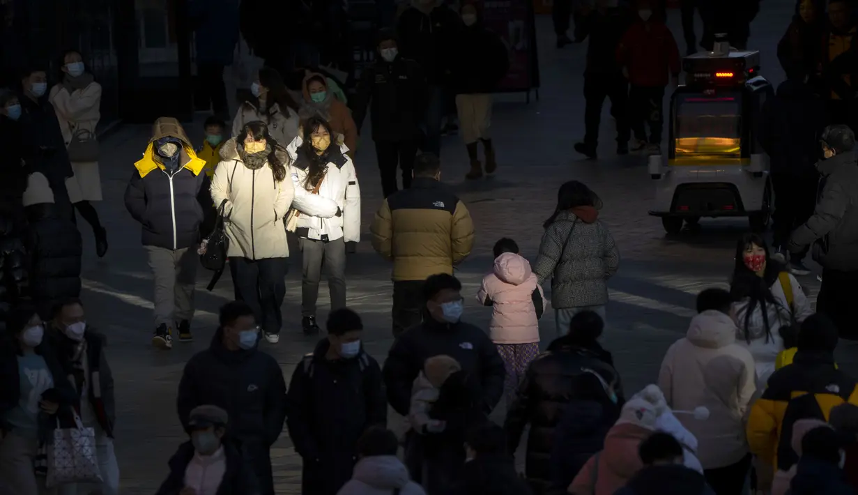 Pengunjung diterangi oleh pantulan sinar matahari saat mereka berjalan melalui pusat perbelanjaan pada hari terakhir minggu liburan Tahun Baru Imlek di Beijing, Jumat, 27 Januari 2023. (AP Photo/Mark Schiefelbein)