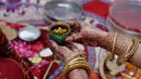 Seorang wanita Hindu yang sudah menikah melakukan ritual festival Karva Chauth di Ahmadabad,  Kamis (17/10/2019). Selama festival Karva Chauth, wanita-wanita yang sudah menikah di India berpuasa sepanjang hari dan memohon umur panjang serta keselamatan untuk suami mereka. (AP/Ajit Solanki)