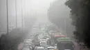Suasana lalu lintas saat kabut tebal akibat polusi menyelimuti kota Delhi, India (1/12). Pemerintah ibu kota mempertimbangkan untuk memberlakukan pembatasan penggunaan kendaraan bermotor menurut Menteri, Arvind Kejriwal. (REUTERS/Cathal McNaughton)