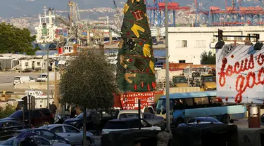 Pakaian dan peralatan milik petugas pemadam kebakaran yang tewas dalam ledakan di Pelabuhan Beirut diletakkan pada sebuah pohon Natal di Beirut, Lebanon (20/12/2020). Pohon Natal ini didirikan pada Minggu (20/12) di dekat Pelabuhan Beirut. (Xinhua/Bilal Jawich)
