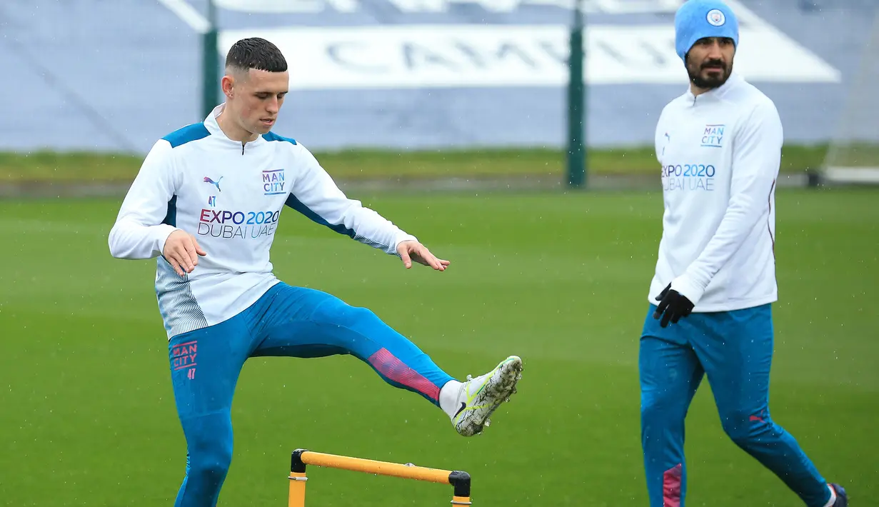 Gelandang Manchester City Phil Foden (kiri) dan Ilkay Gundogan ambil bagian dalam sesi latihan di Manchester, Selasa (12/4/2022). Manchester City akan bertandang ke markas Atletico Madrid untuk melakoni laga kedua perempat final Liga Champions, Kamis 14 April 2022. (Lindsey Parnaby/AFP)