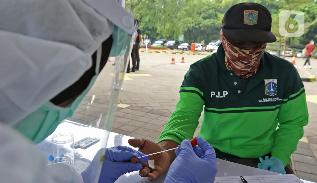 Petugas penggali makam sedang mengikuti rapid test di TPU Pondok Ranggon, Jakarta, Kamis (2/7/2020). HUT ke-74 Bhayangkara, Direktorat Lalu Lintas Polda Metro Jaya memberikan pelayanan penerbitan SIM baru gratis bagi penggali makam yang menangani korban Covid-19. (Liputan6.com/Herman Zakharia)