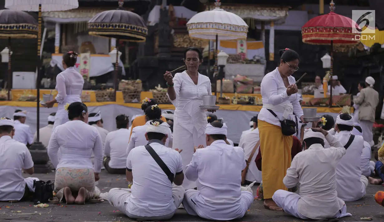 Umat Hindu diberikan air suci dalam prosesi ritual tahunan Purnama Kapat di Pura Besakih  yang ada di kaki Gunung Agung, Karangasem, Bali, Kamis (5/10). Ritual itu diadakan di wilayah rawan bencana erupsi Gunung Agung. (Liputan6.com/Gempur M Surya)