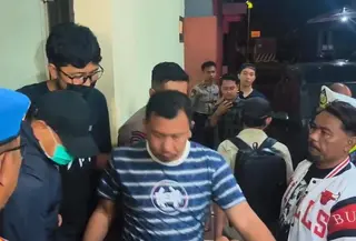 Bupati Sudewo berjaket biru, bertopi hitam dengan memakai masker dinaikan ke mobil dengan kawalan ketat aparat Polres Kudus