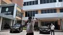 Pengunjung mengenakan masker melintasi kendaraan dinas Menteri Kesehatan RI saat menjenguk pasien positif Corona di RSPI Prof. DR. Saroso, Sunter, Jakarta, Senin (2/3/2020). (merdeka.com/Iqbal S. Nugroho)