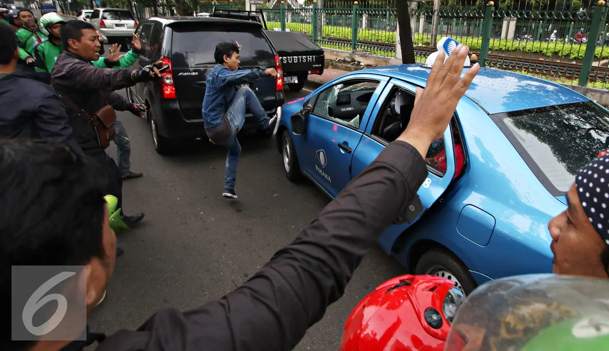 Pengendara ojek online merusak dan melakukan sweeping di kawasan Senayan, Jakarta, Selasa (22/3). Pascabentrok ojek online melakukan sweeping dan perusakan terhadap taksi serta bajaj yang melintas di kawasan tersebut. (Liputan6.com/Immanuel Antonius)