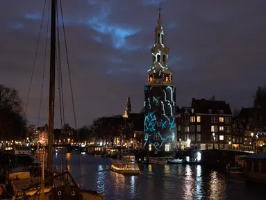 Karya seni berjudul "The Cracks" oleh Karolina Howorko diproyeksikan pada Menara Montelbaan selama Amsterdam Light Festival di Amsterdam, Belanda, 27 November 2019. Festival dengan tema "DISRUPT!" tersebut digelar mulai 28 November hingga 19 Januari 2020 mendatang. (AP/Peter Dejong)