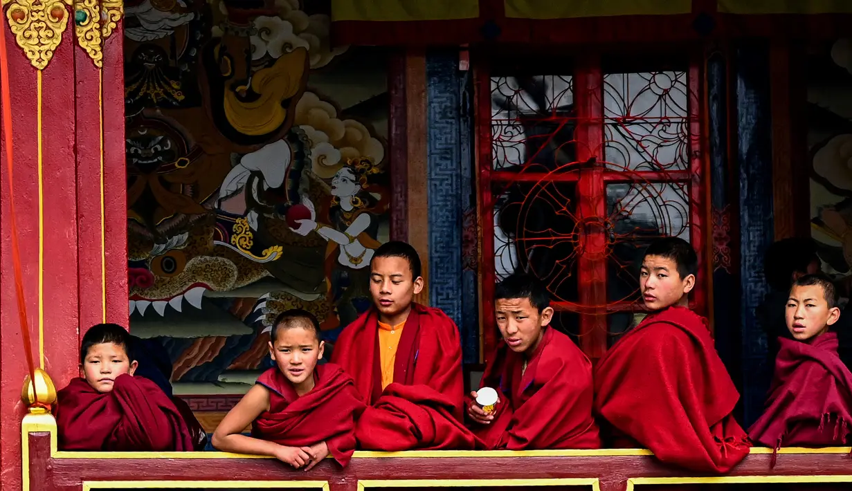 Seorang biksu Buddha muda menikmat teh paginya saat bersama biksu lainnya. Menurut kebiasaan masa lalu, dalam keluarga dengan tiga anak laki-laki, anak laki-laki tengah wajib militer ke biara dan dalam keluarga dengan dua anak laki-laki, anak bungsu dilantik ke dalam biara. (AFP/Arun Sankar)