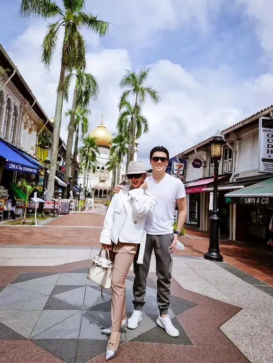 Liburan di Singapura, pasangan yang menikah sejak 2019 ini kompak mengenakan atasan putih dipadu celana panjang nuansa coklat dan abu-abu. @princessyahrini.