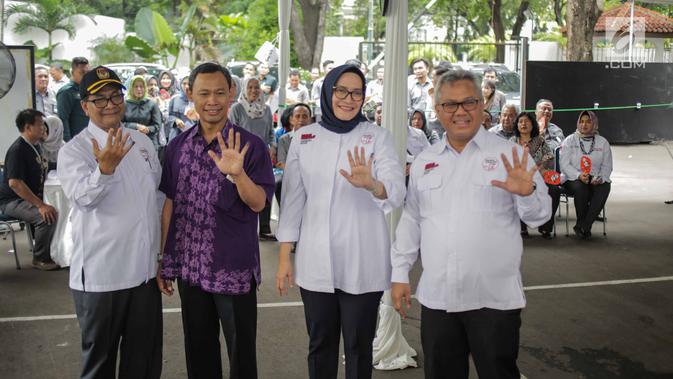 Ketua KPU Arief Budiman (kanan) bersama Komisioner KPU menunjukkan jari bertinta usai mencoblos dalam simulasi pemungutan dan penghitungan suara Pemilu 2019 di halaman Gedung KPU, Jakarta, Selasa (12/3). (Liputan6.com/Faizal Fanani)