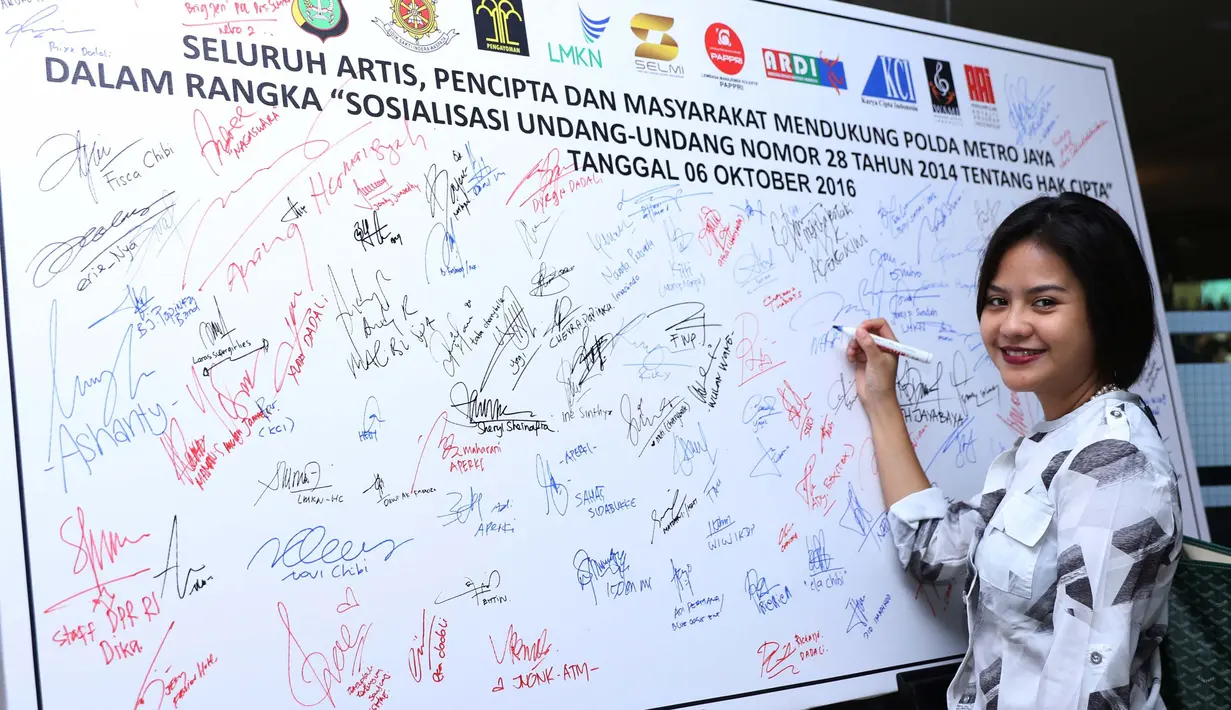 Penyanyi Mytha Lestari membubuhkan tanda tangan dukungan pada acara sosialisasi UU No 28 Tahun 2014 tentang Hak Cipta di Polda Metro Jaya, Jakarta, Kamis (6/10). Sosialisasi dihadiri sejumlah artis, musisi hingga pencipta lagu. (Liputan6.com/Gempur M)