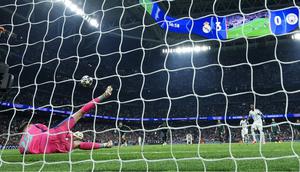 Kiper Manchester City, Gianluigi Donnarumma, melakukan penyelamatan terhadap eksekusi penalti penyerang Real Madrid, Vinicius Junior, pada leg pertama 16 besar Liga Champions 2025/2026 di Santiago Bernabeu, Kamis (12/3/2026) dini hari WIB. (Thomas COEX / AFP)