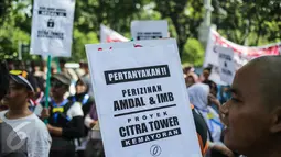 Warga Kebon Kosong Kecamatan Kemayoran membawa poster dalam unjuk rasa di Balai Kota Jakarta, Senin (3/4). Mereka menyampaikan aspirasi pembelaan terhadap dampak lingkungan yang terjadi dari pembangunan perkantoran Citra Tower (Liputan6.com/Faizal Fanani)
