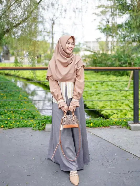 Melengkapi penampilannya, Anisa mengenakan hijab warna coklat muda, flat shoes, dan mini bag warna senada. (Instagram/anisarahma_12).