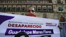Maria de la Luz Flores memegang poster putrinya Guadalupe Morales Flores yang hilang pada 7 September 2020 dan ditemukan 29 Maret 2021 saat protes di luar Istana Nasional menuntut jawaban dari pemerintah tentang orang-orang hilang di Mexico City, Meksiko, 13 Desember 2021. (AP Photo/Marco Ugarte)