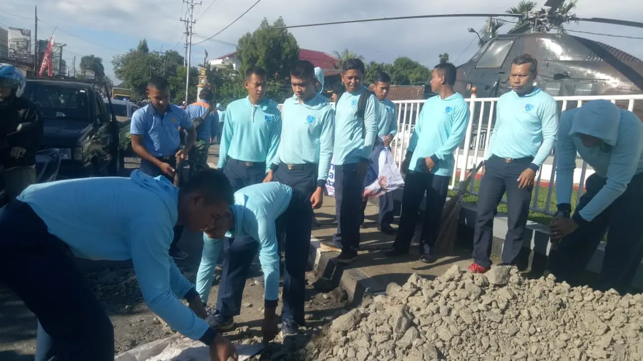 Sejumlah Prajurit TNI  dari Angkatan Udara Lanud Atang Sendjaja Bogor menambal jalan rusak di ruas Jalan Raya Semplak, Kecamatan Bogor Barat, Kota Bogor, Kamis (2/5/2019). (Liputan6.com/Achmad Sudarno)