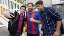 Reza Parastesh, seorang warga Iran yang memiliki wajah mirip Lionel Messi diajak selfie oleh warga di jalanan Tehran, Iran, Senin (8/5/2017). (AFP/Atta Kenare)