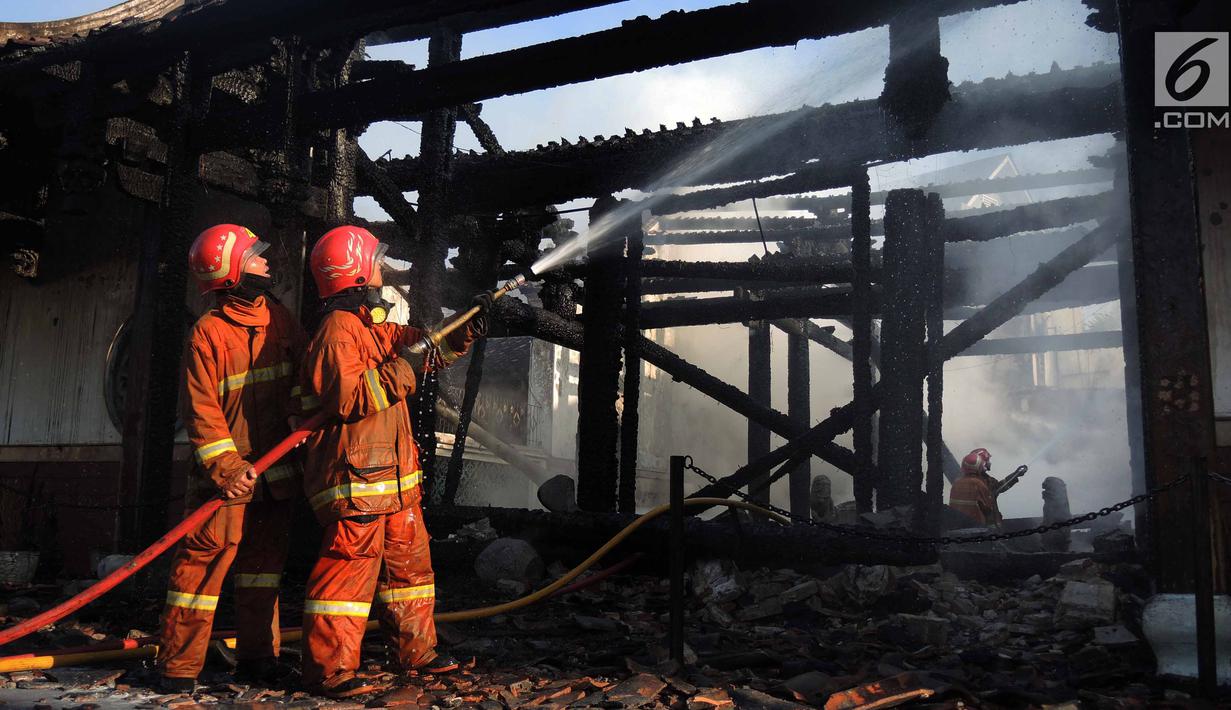 Petugas damkar mendinginkan sisa kebakaran yang melanda kompleks Kelenteng Tay Kak Sie di Gang Lombok, Semarang, Kamis (21/3). Bangunan yang terbakar merupakan rumah abu yang berada satu kompleks dengan bangunan utama kelenteng. (Liputan6.com/Gholib)