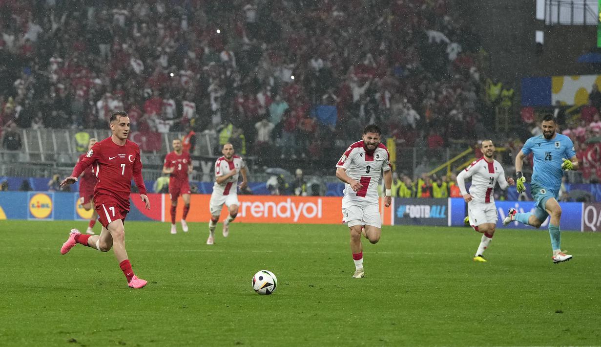 Striker Timnas Turki, Kerem Akturkoglu (kiri) menggiring bola untuk mencetak gol ketiga timnya ke gawang Timnas Georgia yang telah kosong pada laga matchday pertama Grup F Euro 2024 di Westfalenstadion, Dortmund, Jerman, Selasa (18/6/2024). (AP Photo/Alessandra Tarantino)