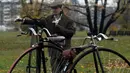 Seorang penggemar sepeda mengenakan kostum sejarah sambil menuntun Penny Farthing atau dikenal sebagai sepeda roda tinggi selama kompetisi tradisonal 'One Mile Race' di Praha, Republik Ceko pada 3 November 2018. (Photo by Michal CIZEK / AFP)