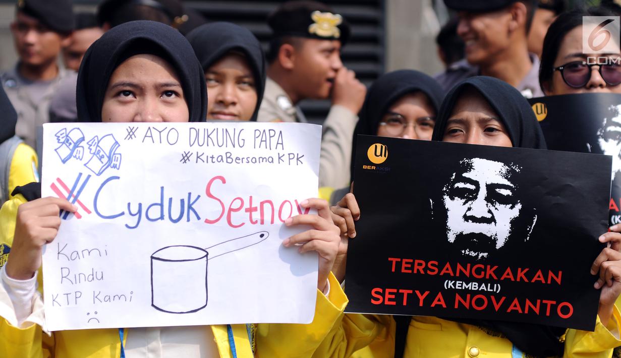Sejumlah mahasiswa yang tergabung dalam UI Beraksi membentangkan tulisan saat aksi di depan Gedung KPK, Jakarta, Jumat (13/10). Mereka meminta KPK segera menetapkan kembali status tersangka kepada Setya Novanto. (Liputan6.com/Helmi Fithriansyah)