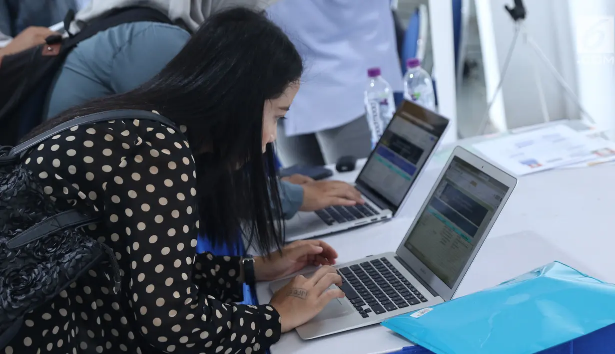 Pencari kerja mengisi form di salah satu stand perusahaan saat gelaran Job for Career Festival 2018 di area Stadion Gelora Bung Karno, Jakarta, Selasa (27/11). Gelaran ini diikuti puluhan perusahan baik BUMN maupun swasta (Liputan6.com/Helmi Fithriansyah)