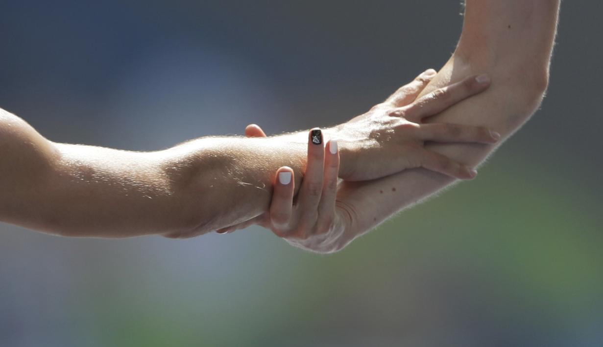 Pelari Selandia Baru, Nikki Hamblin, dan pelari AS, Abbey D'Agostino, bersalaman usai finis pada lari 5000m putri Olimpiade Rio 2016 di Olympic Stadium, Rio de Janeiro, Brasil, (16/8/2016). (AP/David J. Phillip)