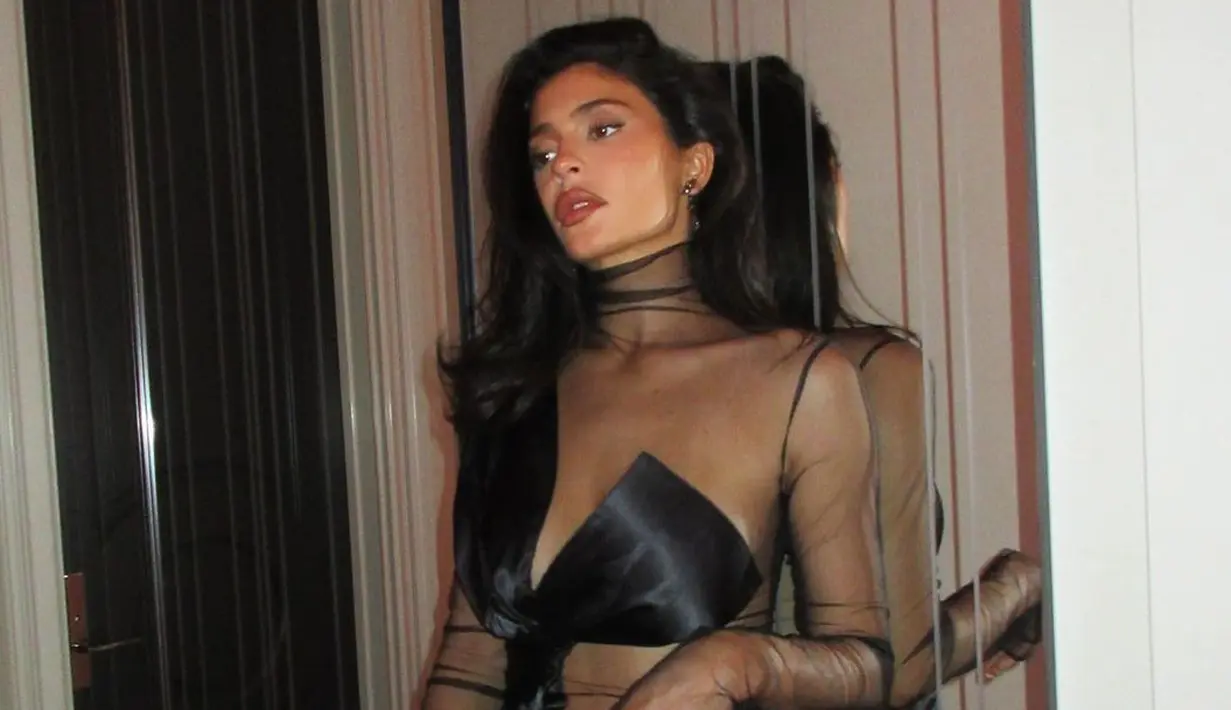 <p>Kali ini ia mengenakan see through mesh dress berwarna hitam dengan bikini cover. Busana yang menunjukkan lekuk tubuh membuatnya tampil seksi. [Instagram/kyliejenner]</p>