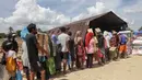 Warga pun masih kekurangan pasokan bahan pangan dan obat-obatan. Tampak dalam foto, warga mengantre untuk menerima pasokan makanan pokok dan air minum di pos logistik yang dibangun oleh warga setempat untuk menampung bantuan yang masuk, di desa Lintang Bawah di Aceh Tamiang, Sumatera Utara, pada Kamis 11 Desember 2025. (Aditya Aji/AFP)